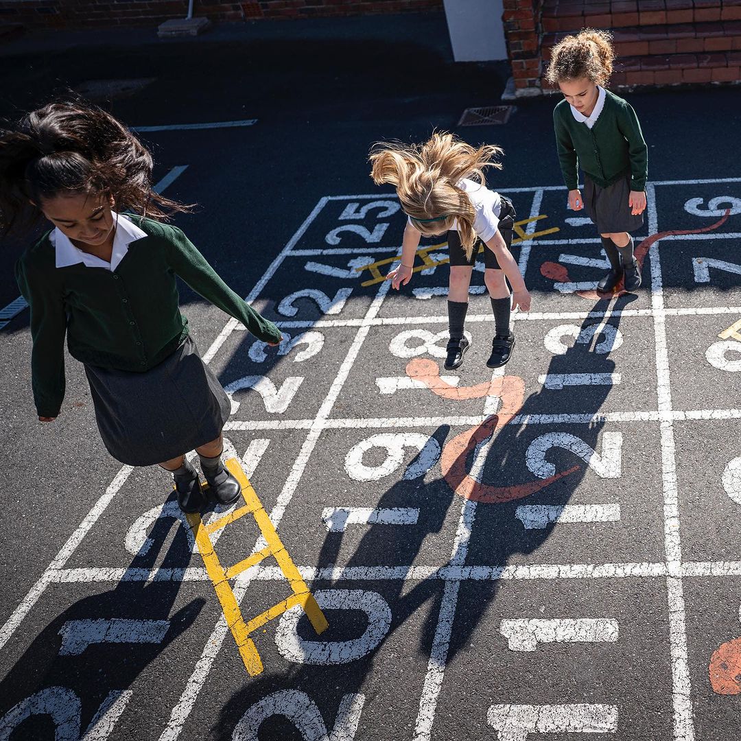 vivobarefoot school playground photo three children play on painted floor numbers