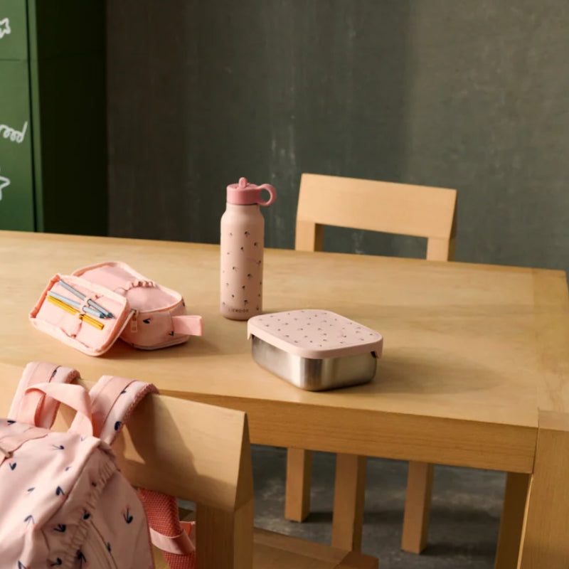 A wooden table with a matching school lunch box and water bottle