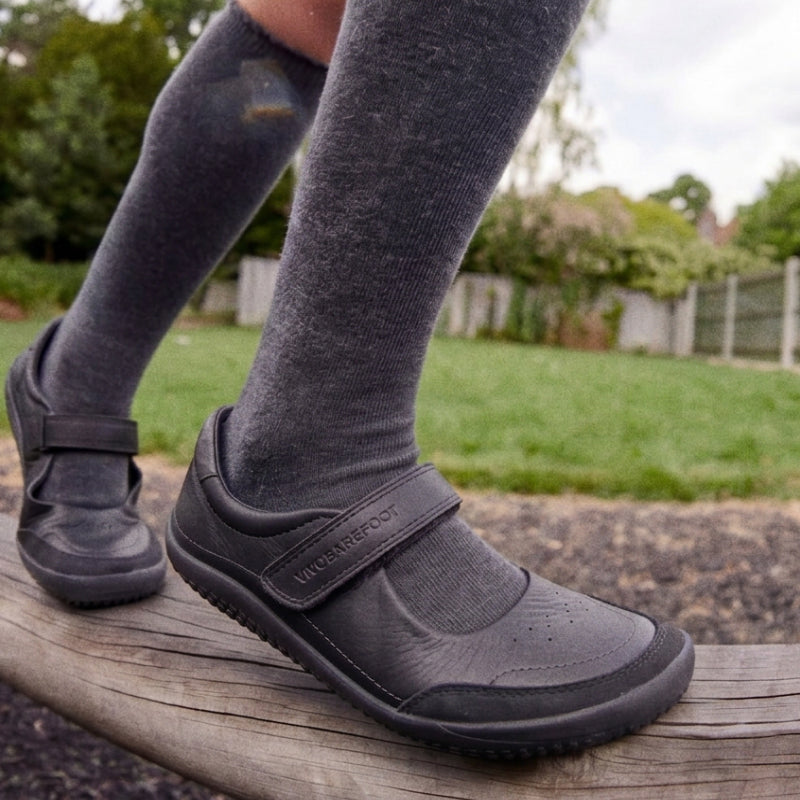 Vivobarefoot school shoes worn with dark grey knee high socks