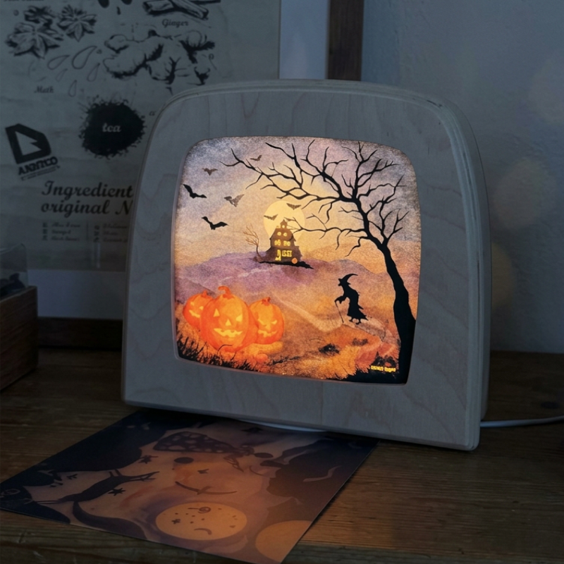 Halloween scene featuring a silhouette of a witch, spooky house and orange pumpkins