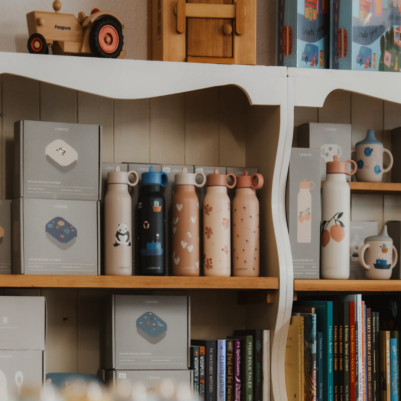 Reusable patterned waterbottles on a shelf in the SMALL-FOLK store